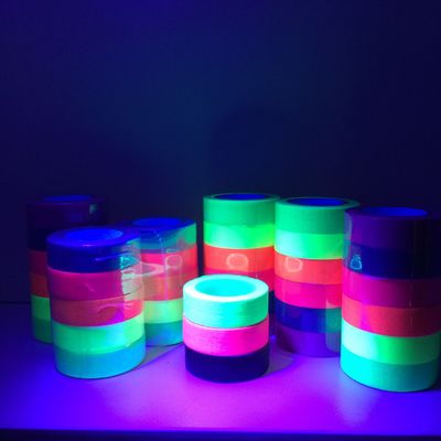 Cinta amonestadora de la cinta adhesiva de algodón de la cinta fluorescente de neón luminosa ligera negra ULTRAVIOLETA del paño para el partido proveedor